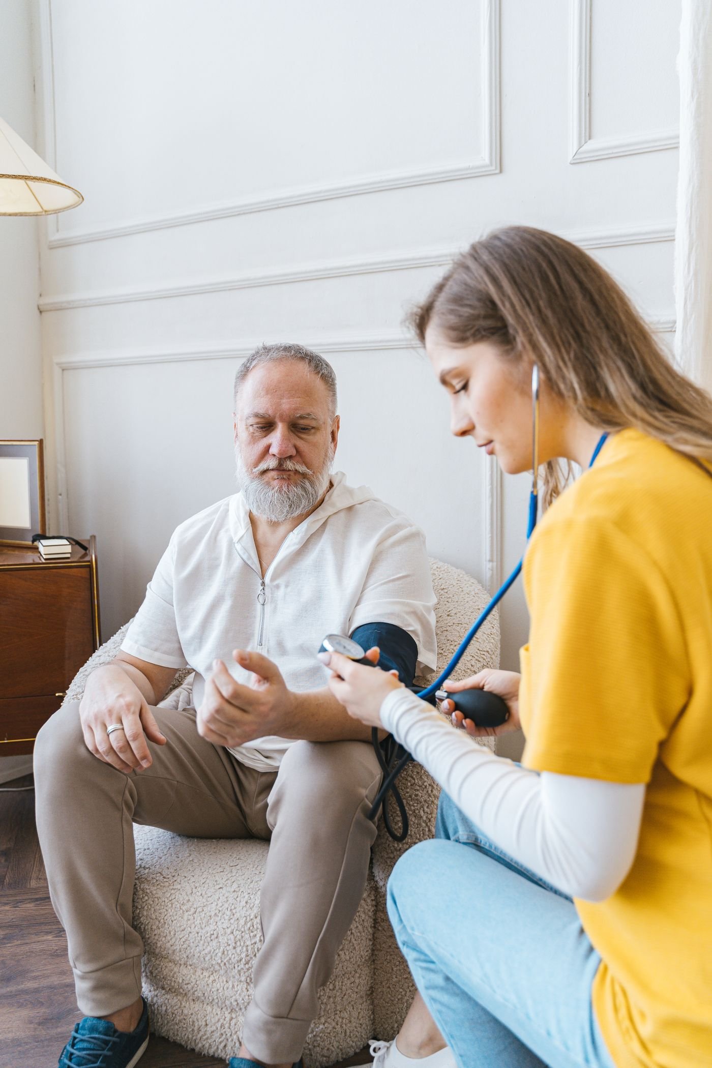 A nurse measuring an elderly patient’s blood pressure at home